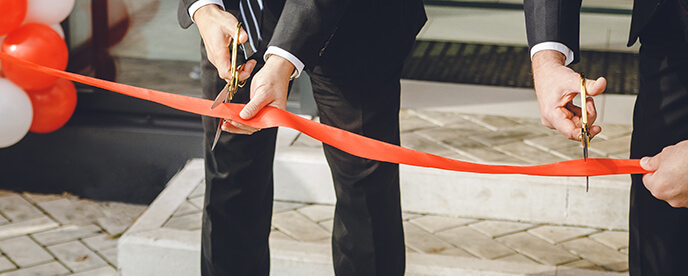 people cutting ribbon at grand opening of a new store