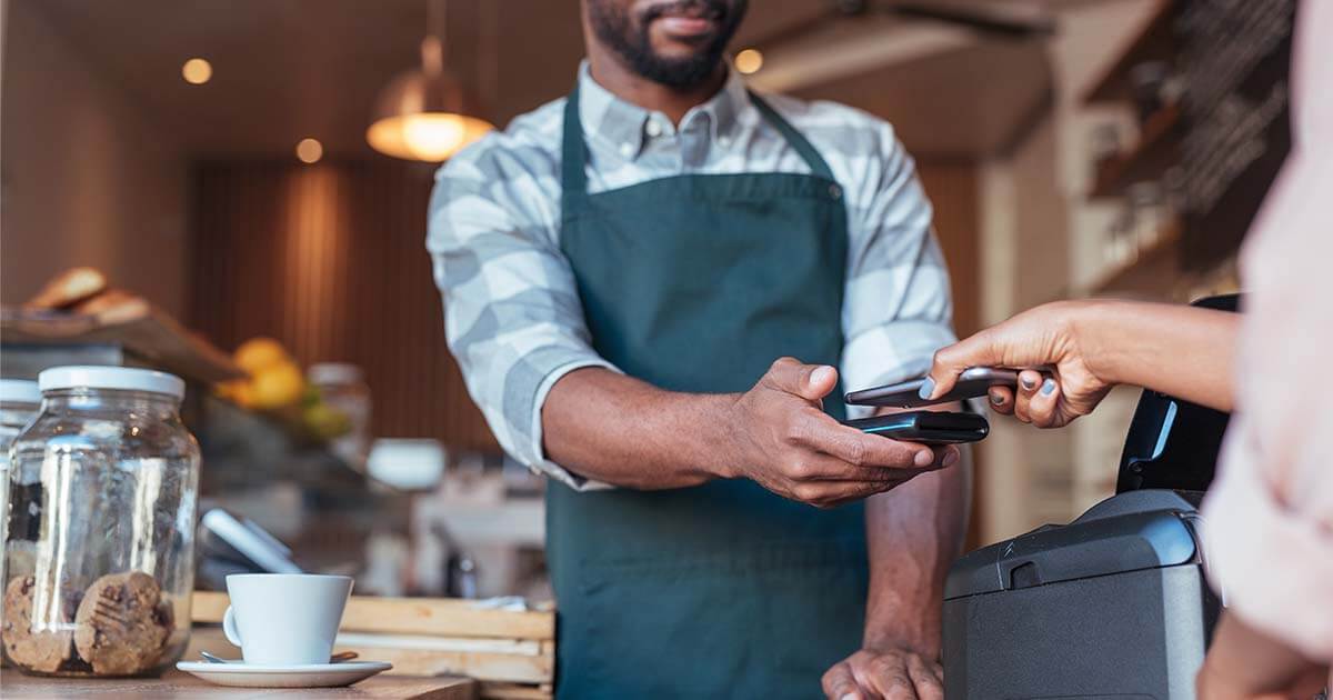 man-holding-pos-system-at-coffee-shop