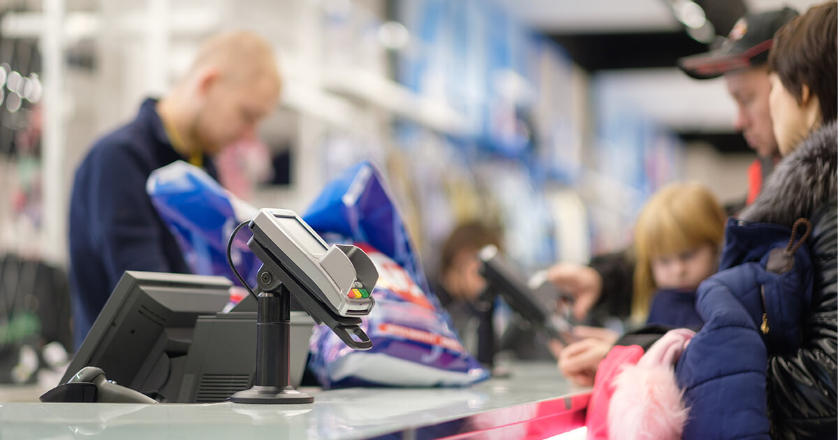 family stands at payment terminal in a store