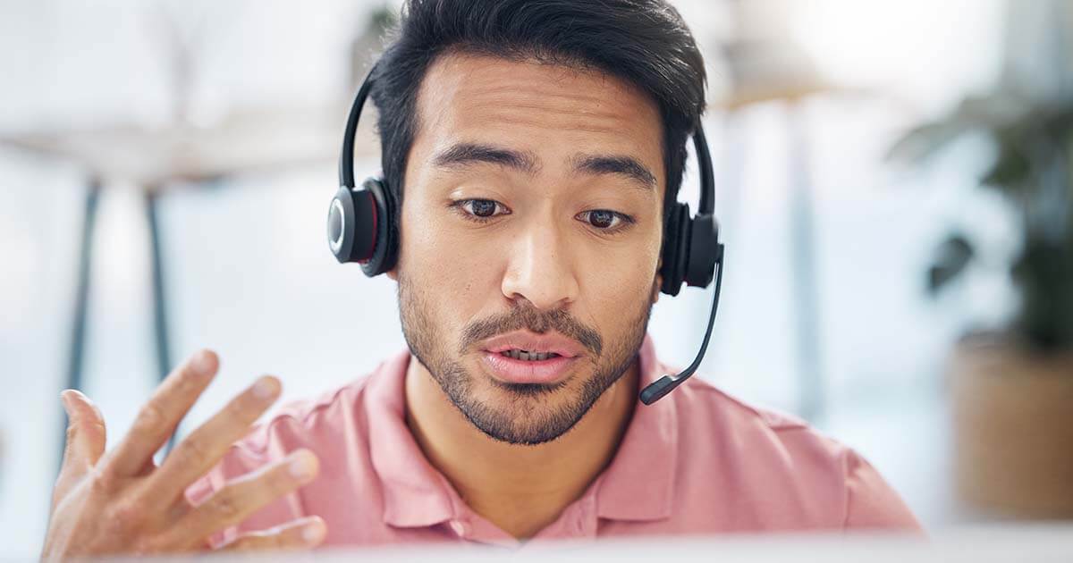 man wearing headset working IT support desk