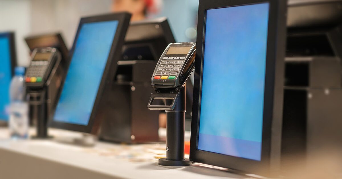 digital kiosks and payment terminals in a row at a qsr