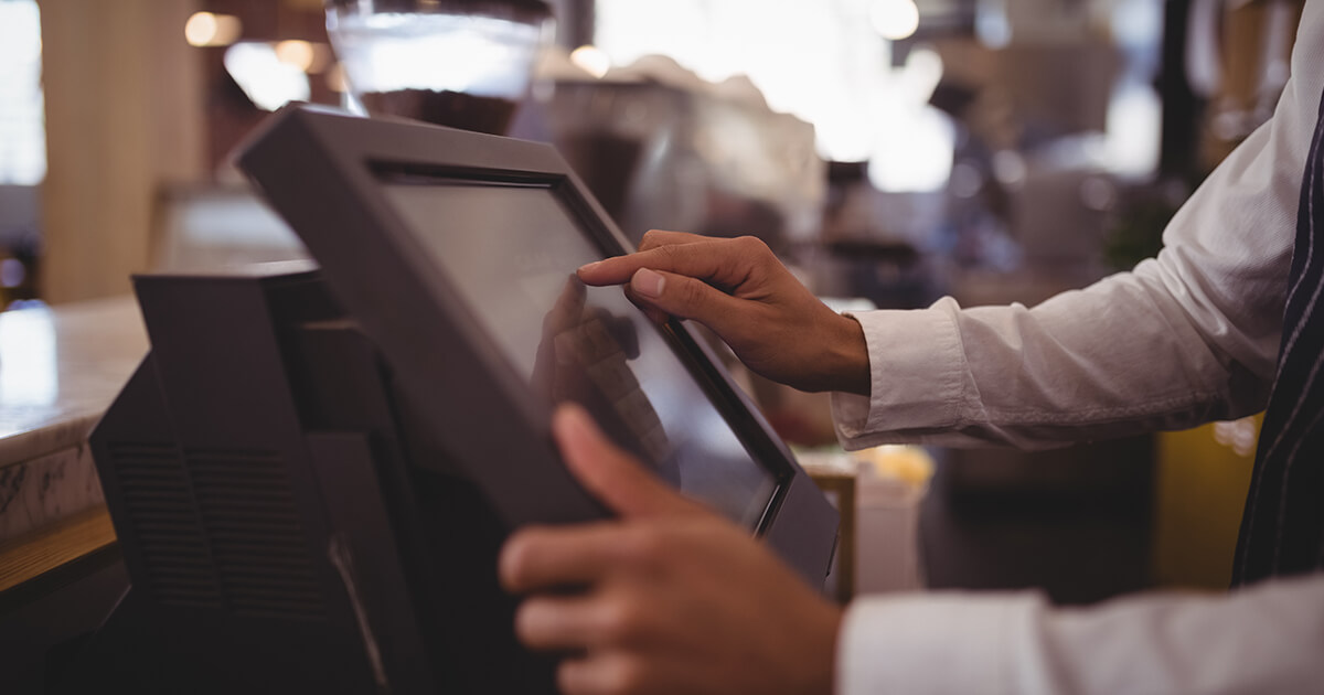 restaurant employee uses touch screen on POS system