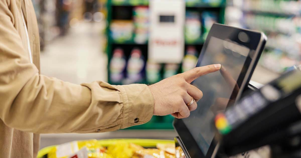 hand on self checkout touch screen