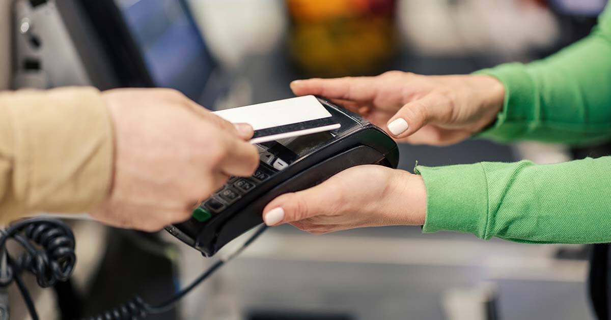 cashier holding POS system for contactless pay