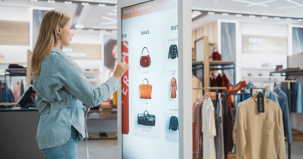 woman interacts with digital kiosk in store