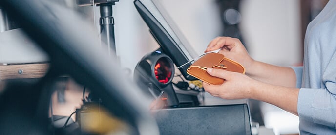 cashier ringing up a wallet at POS system