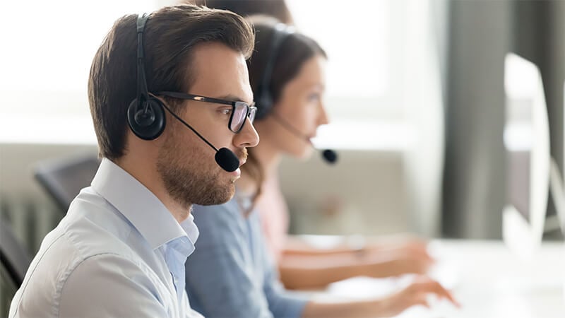 man working while wearing a phone headset