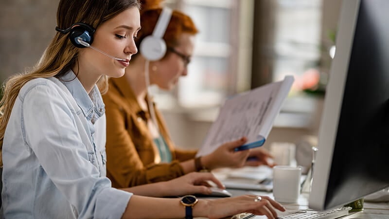 woman working at computer while wearing phone headset