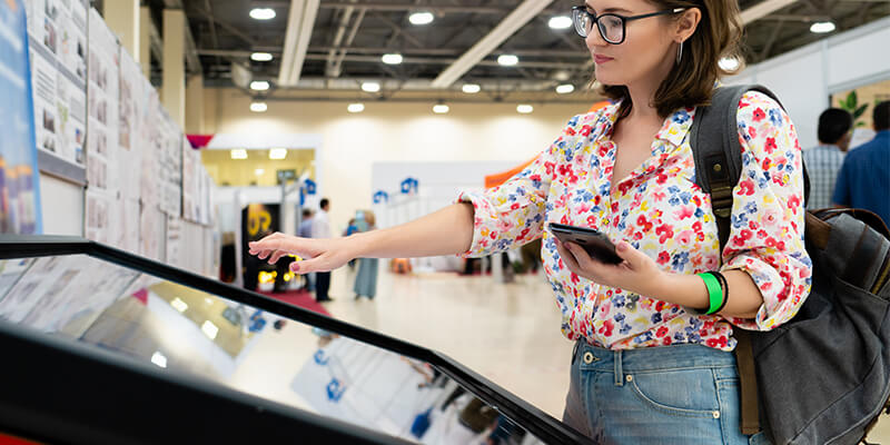 customer interacts with digital kiosk retail technology in store