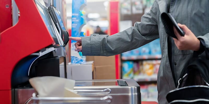 customer paying at pinpad using self-serve checkout retail technology solution