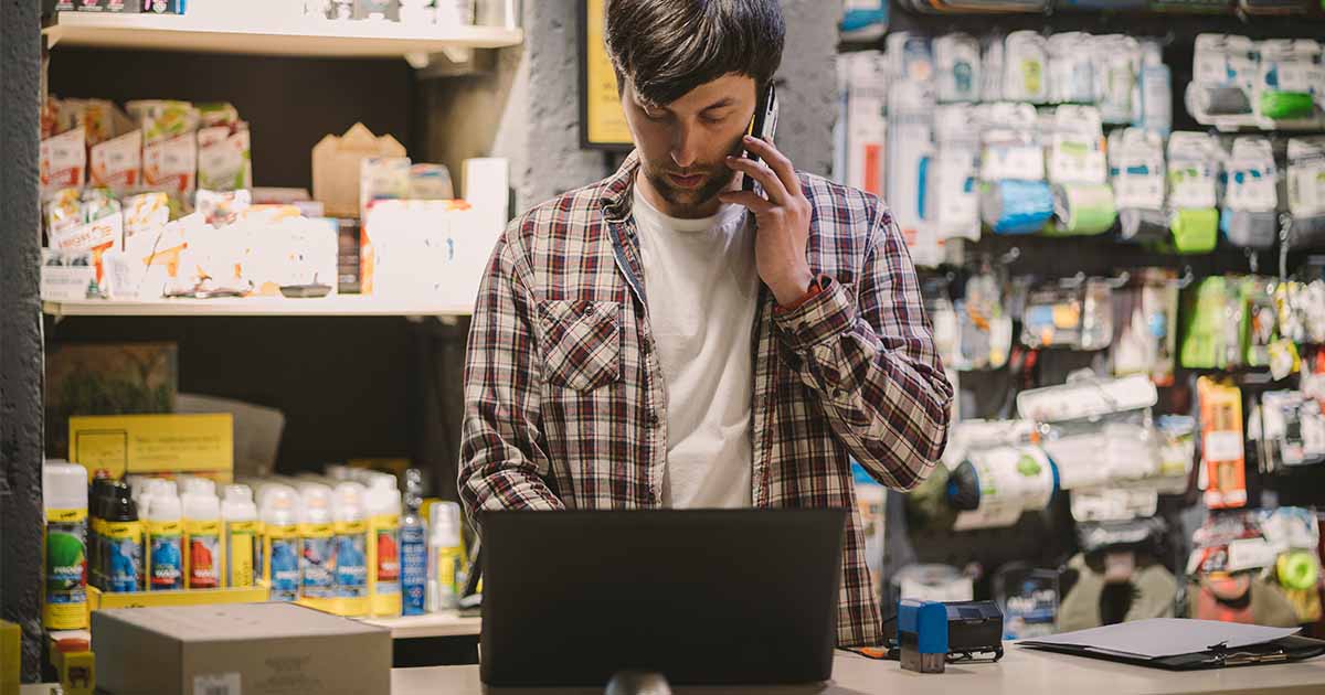 As part of the byod trend, a store employee makes a call on his mobile device.